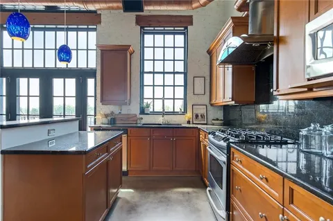 a kitchen with stainless steel appliances granite countertop a stove and a microwave