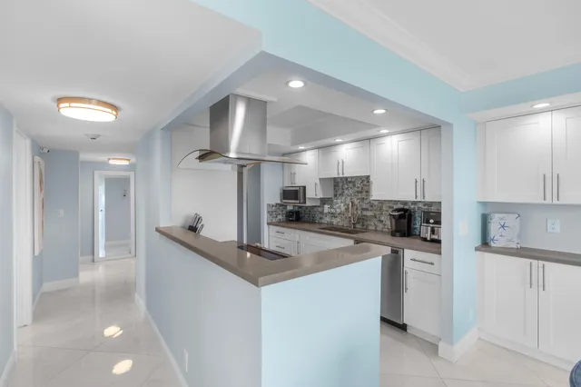 a kitchen with stainless steel appliances kitchen island a refrigerator sink and cabinets