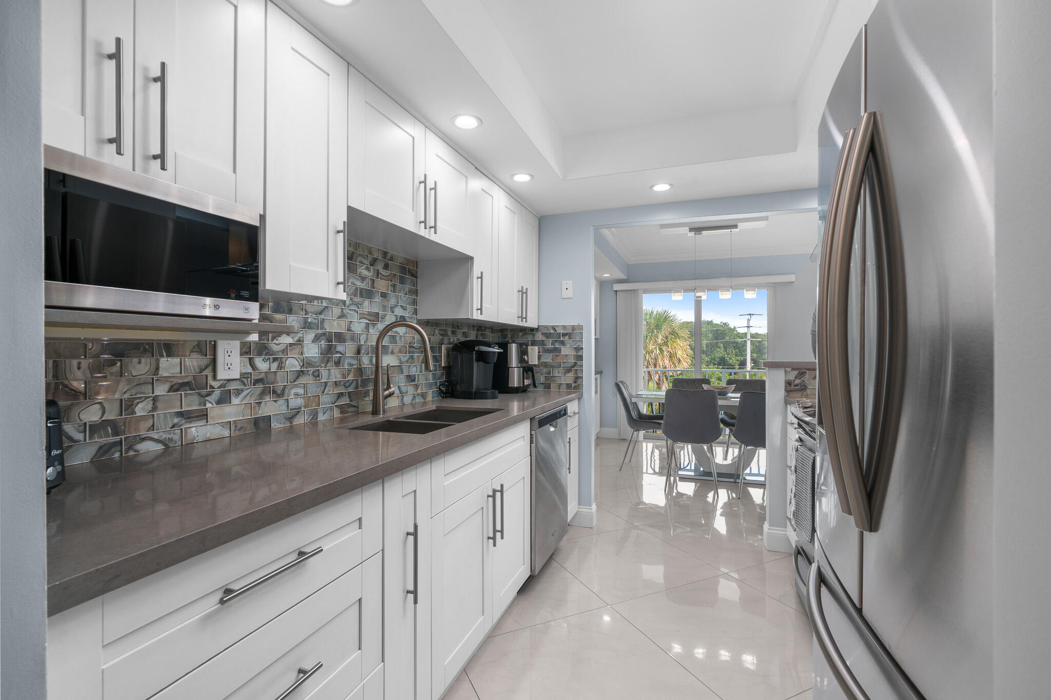 950 Ponce De Leon Road, Unit 401 Boca Raton, FL 33432 - Photo 15 of 35 a kitchen with stainless steel appliances granite countertop a refrigerator a sink a stove and white cabinets