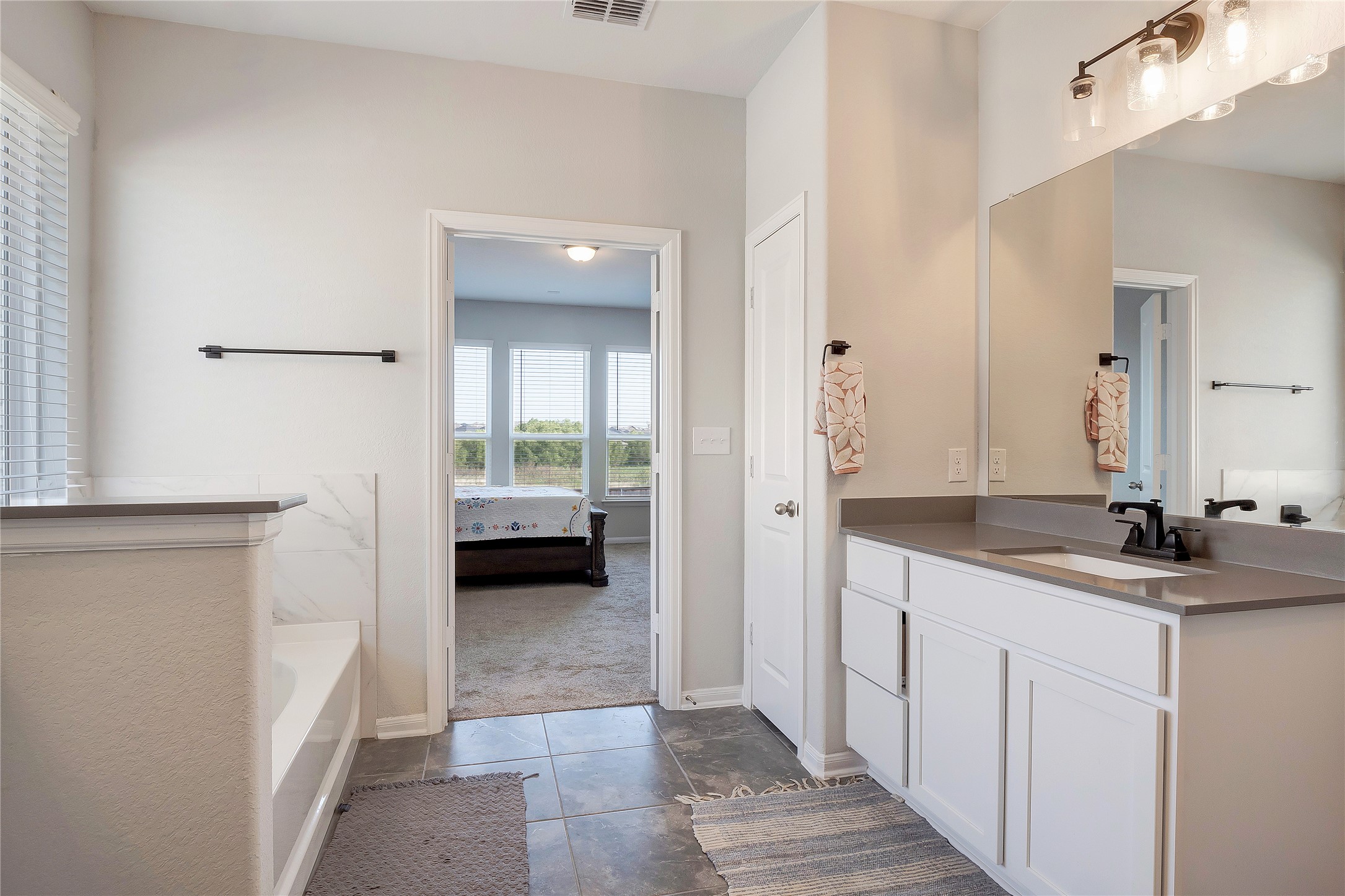 574 Sugar Cane Buda, TX 78610 - Photo 16 of 35 a en suite bathroom with a double vanity sink and mirror