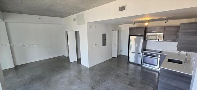 a view of a refrigerator in kitchen and wooden floor