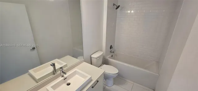 a white toilet sitting next to a bathroom sink and vanity