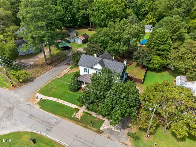 an aerial view of a house with garden space and street view