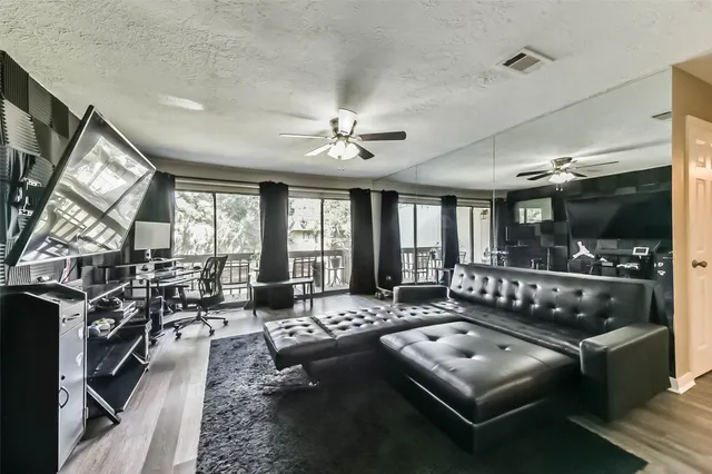 a living room with furniture a chandelier a large window and flat screen tv