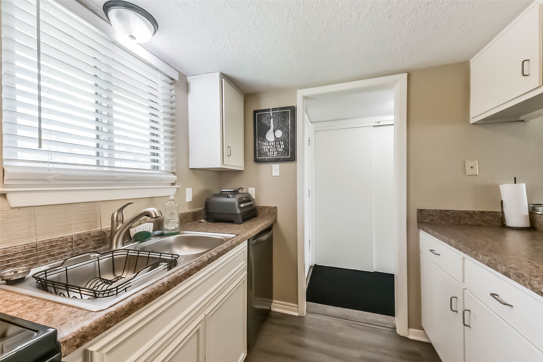 15919 Golf Club Drive, Unit 215 Crosby, TX 77532 - Photo 4 of 16 a kitchen with a sink stove and cabinets