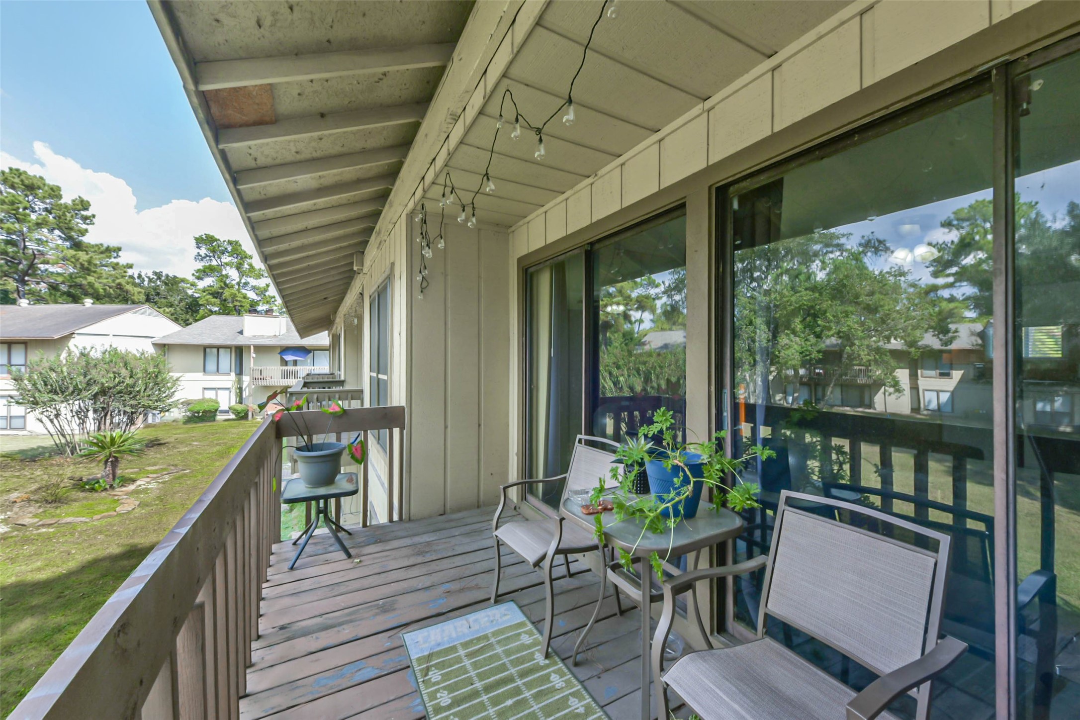 15919 Golf Club Drive, Unit 215 Crosby, TX 77532 - Photo 10 of 16 a balcony with wooden floor outdoor seating and outdoor seating