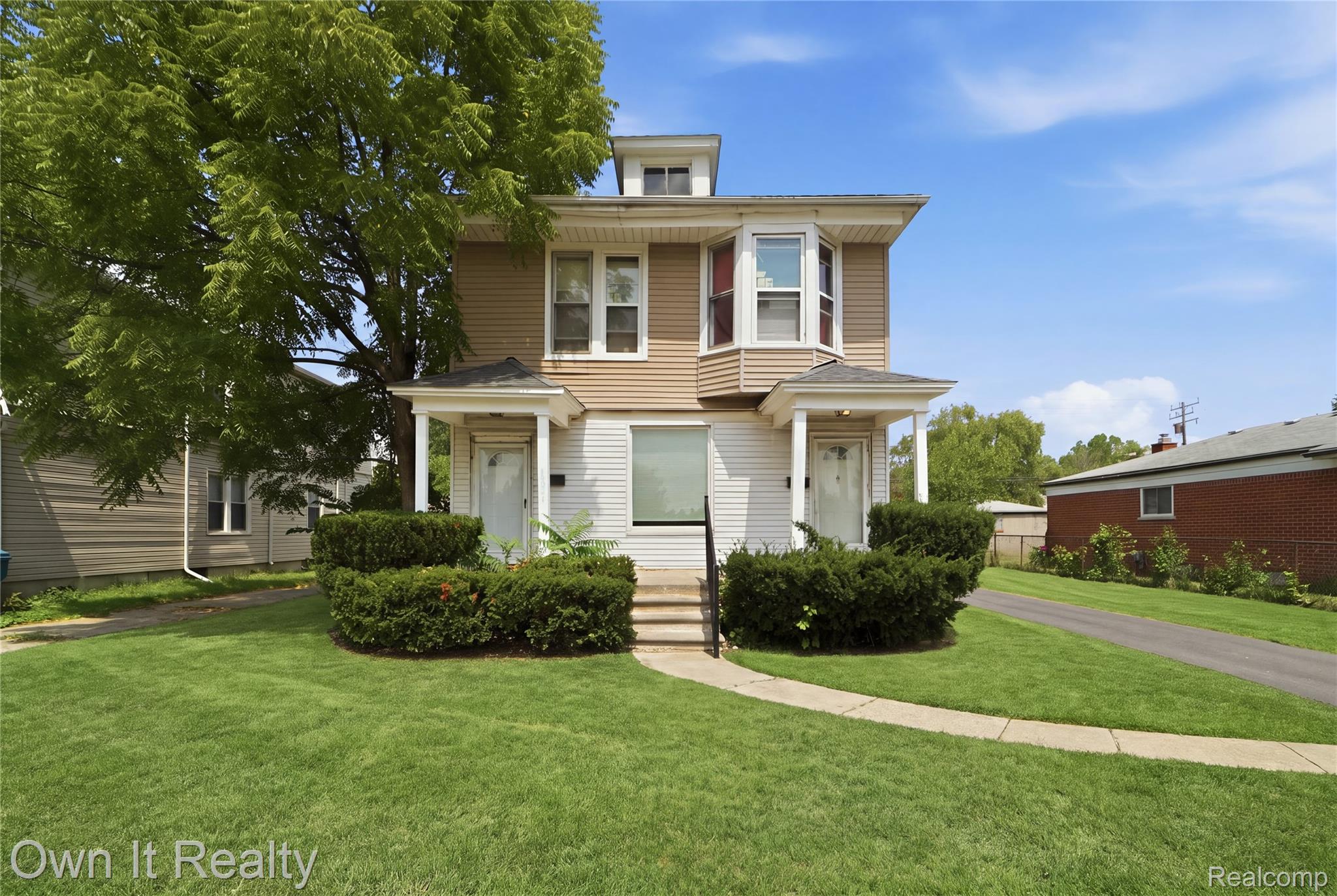 14761 Stephens Road Eastpointe, MI 48021 - Photo 4 of 24 Two-story facade with light-colored siding, a bay window feature, and twin covered entryways