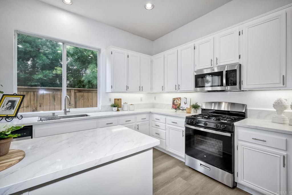 1120 Lassen Peak Place Chula Vista, CA 91913 - Photo 14 of 48 a kitchen with a stove a sink and a microwave