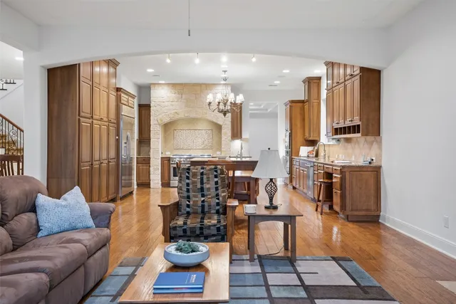 a view of a hallway to a livingroom with wooden floor and furniture