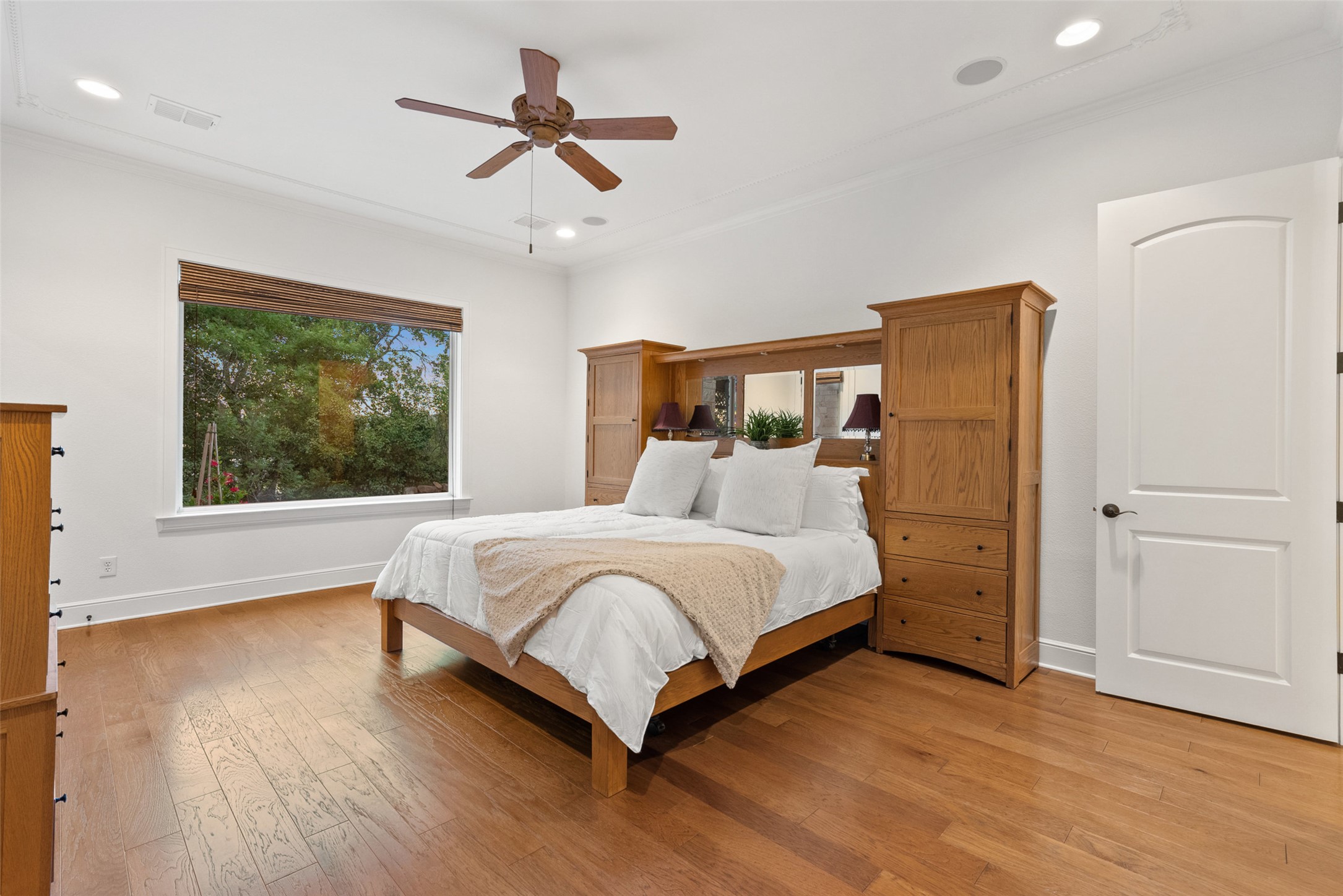 9308 Travertine Cove Austin, TX 78735 - Photo 17 of 40 a bedroom with a large bed chandelier and a window