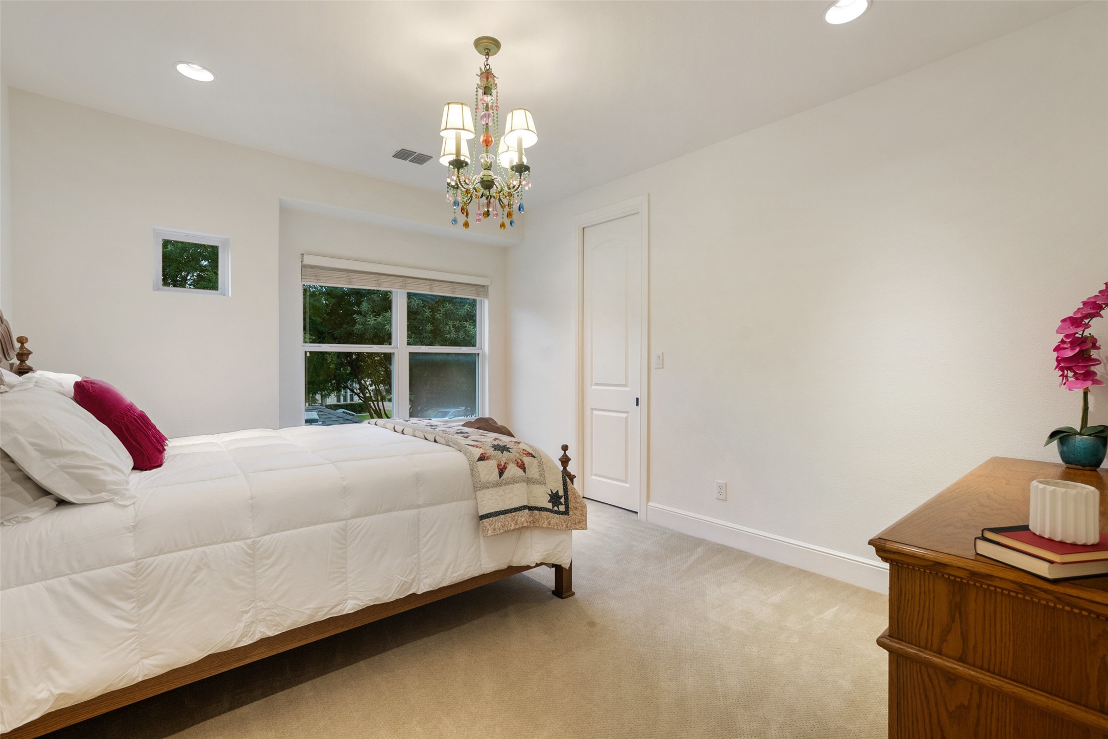 9308 Travertine Cove Austin, TX 78735 - Photo 25 of 40 a bedroom with a bed and a chandelier