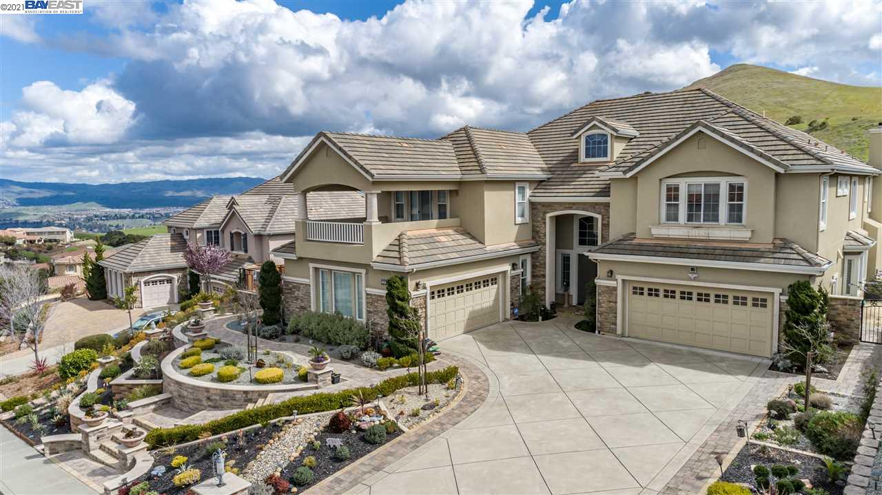 a front view of a house with a yard and potted plants