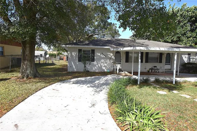 an empty room with wooden floor fan and window