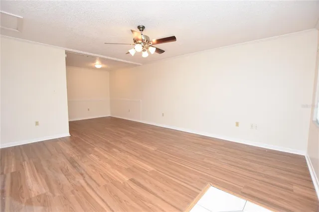 a view of a livingroom with wooden floor and a ceiling fan