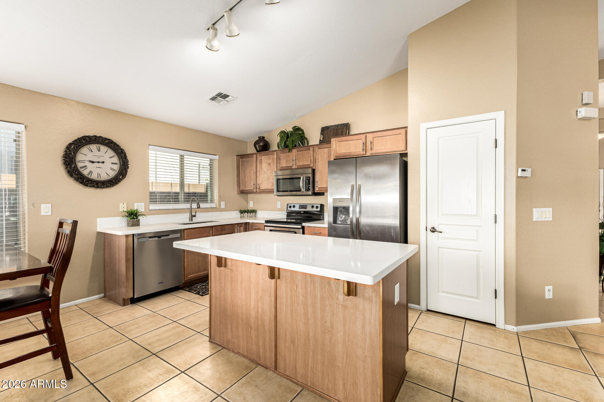 45144 West Desert Garden Road Maricopa, AZ 85139 - Photo 25 of 52 a kitchen with stainless steel appliances granite countertop a refrigerator a sink a stove and white cabinets