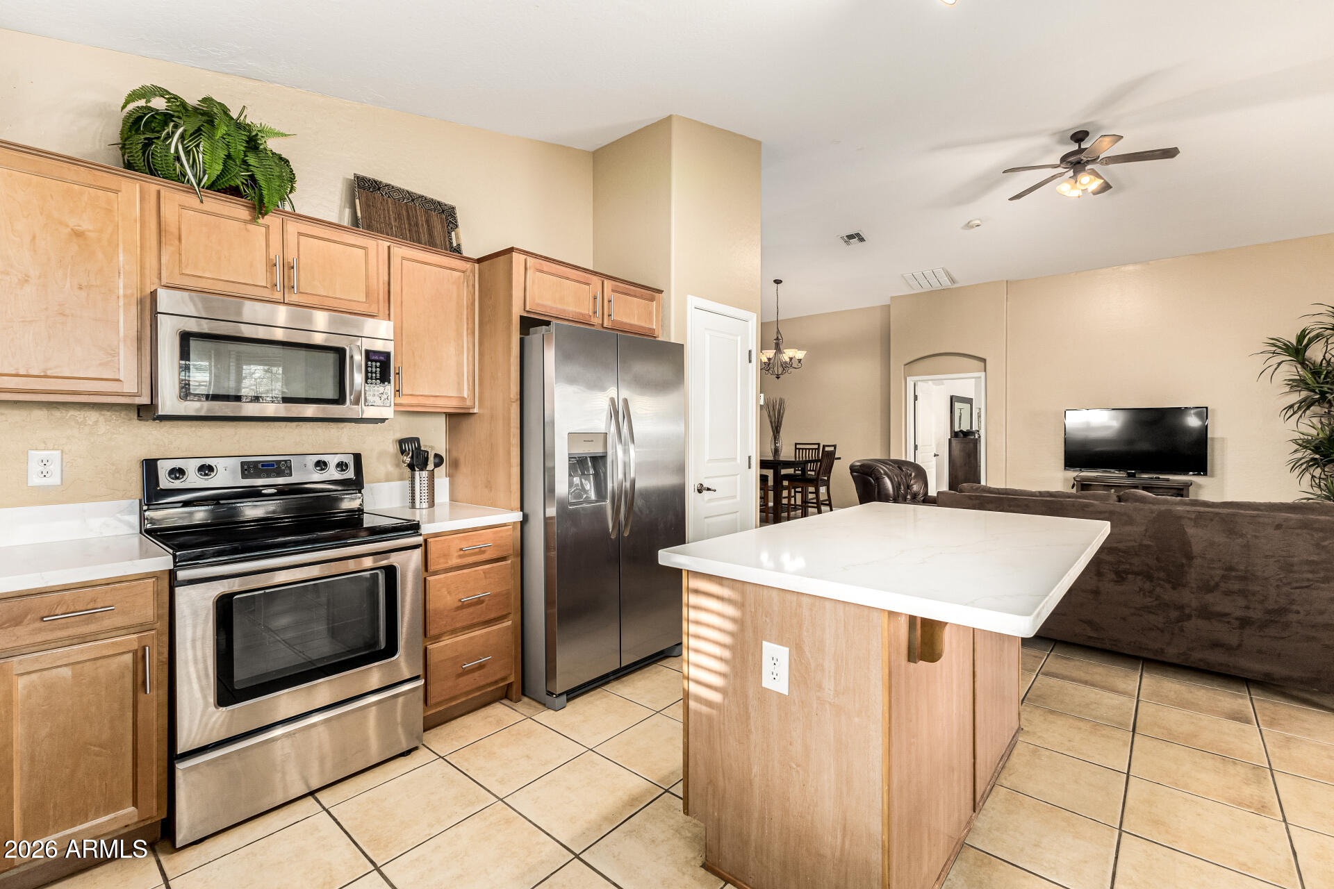 45144 West Desert Garden Road Maricopa, AZ 85139 - Photo 4 of 52 a large kitchen with stainless steel appliances a stove a refrigerator a oven and white cabinets