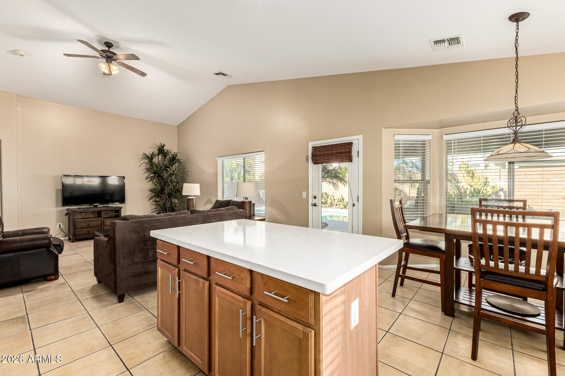 45144 West Desert Garden Road Maricopa, AZ 85139 - Photo 9 of 52 a kitchen with kitchen island a sink dining table and chairs