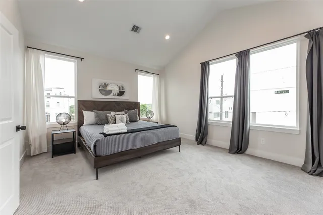 a spacious bedroom with a bed and a window