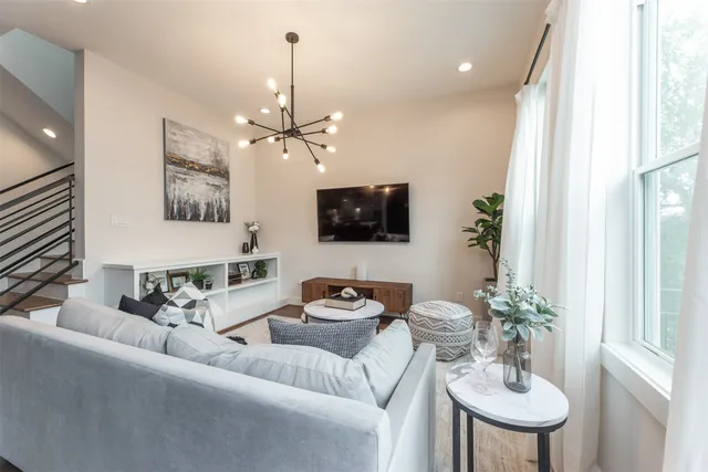 a living room with furniture a chandelier and a flat screen tv