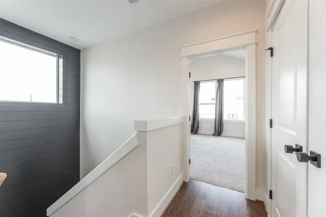 a view of a hallway with wooden floor and entryway