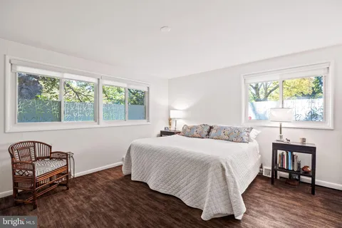 a bedroom with a bed a table and a large window
