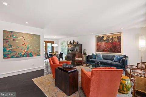 a living room with furniture a flat screen tv and a wall painting