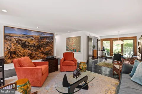 a living room with furniture a rug and a floor to ceiling window