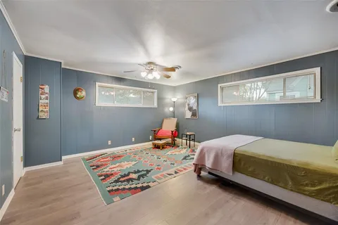 a bed room with a bed and painting on the wall