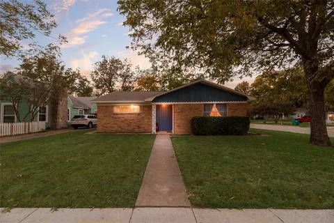 a front view of a house with a yard and trees