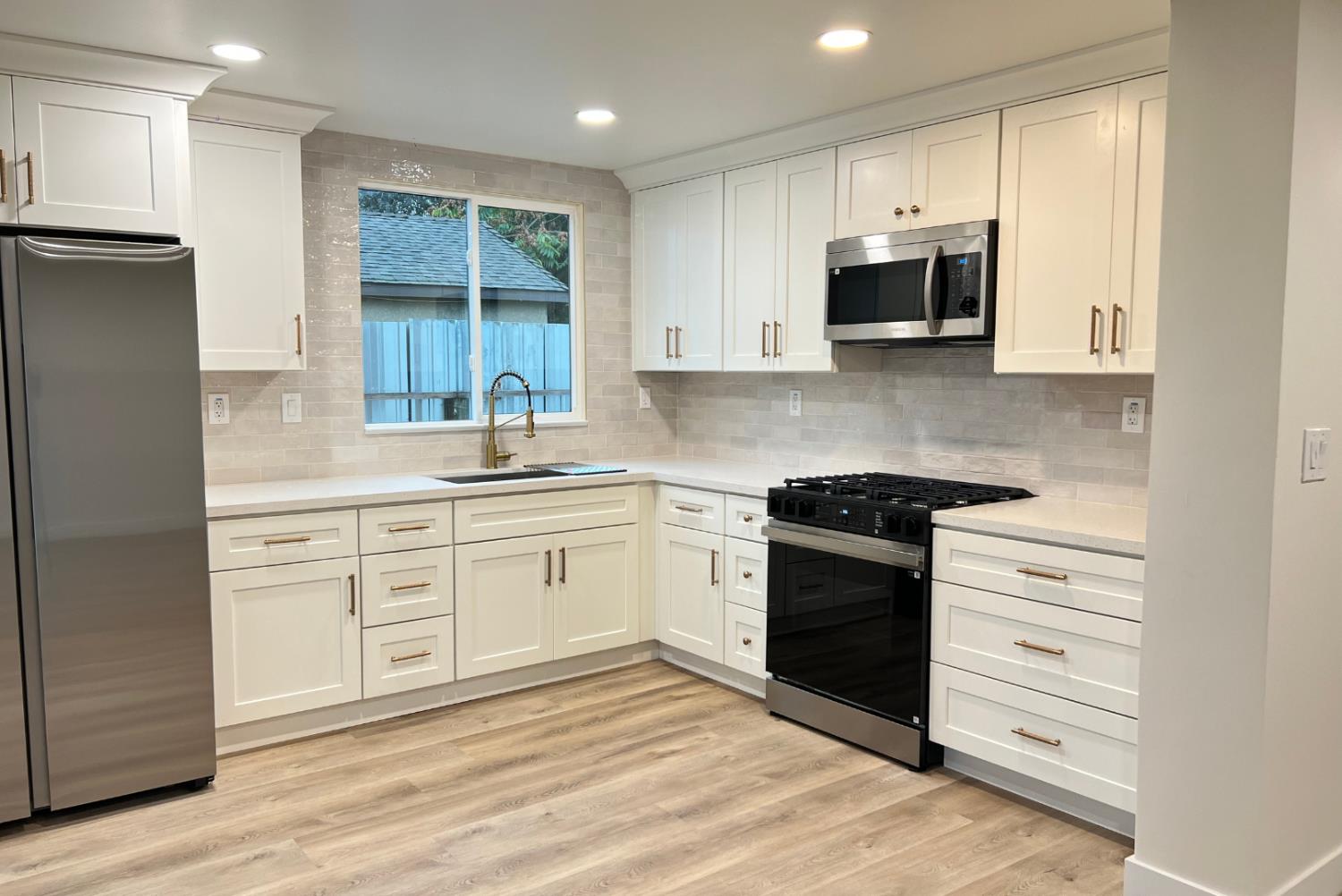 1715 Dallas Street Modesto, CA 95358 - Photo 11 of 35 a kitchen with stainless steel appliances granite countertop white cabinets a sink a stove a refrigerator and a microwave