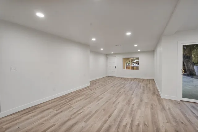 a view of empty room with wooden floor