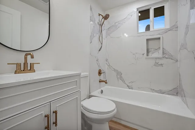 a bathroom with a sink a toilet and a mirror