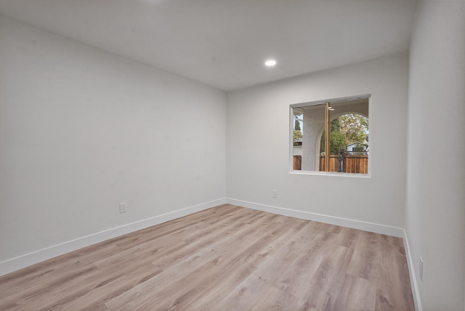 1715 Dallas Street Modesto, CA 95358 - Photo 16 of 35 a view of an empty room with wooden floor and a window