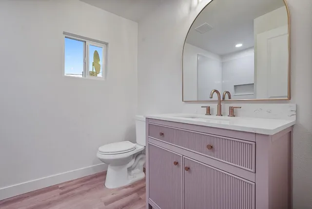 a bathroom with a toilet sink and mirror