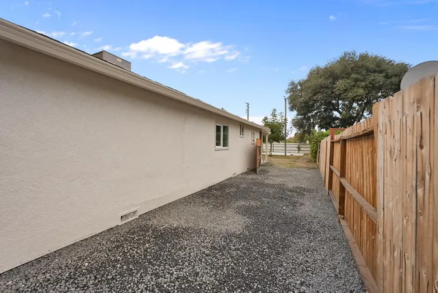 a view of a back yard with wooden fence