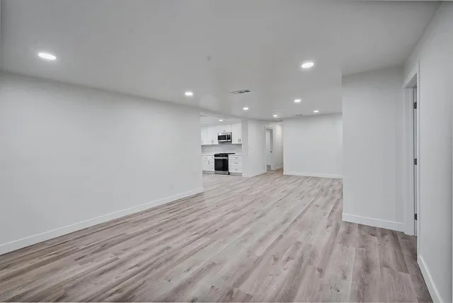 a view of empty room with wooden floor
