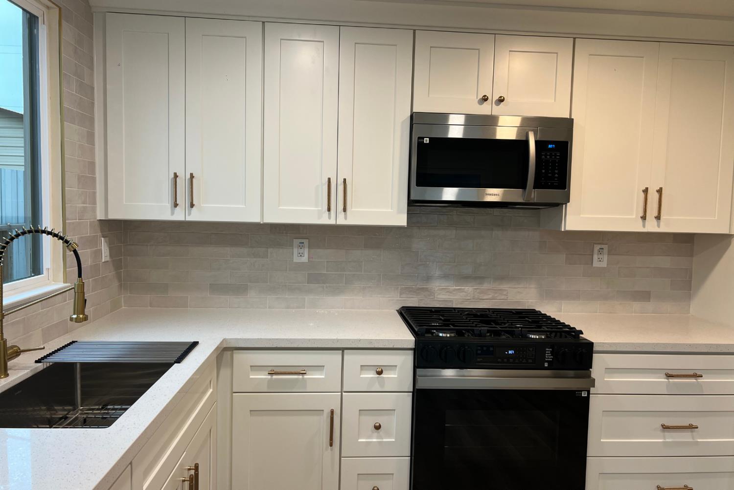 1715 Dallas Street Modesto, CA 95358 - Photo 7 of 35 a kitchen with granite countertop white cabinets and black appliances
