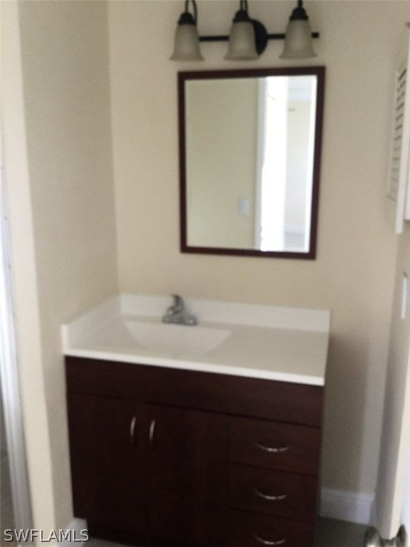 5311 Summerlin Road, Unit 1114 Fort Myers, FL 33919 - Photo 4 of 5 a bathroom with a sink a mirror and cabinets