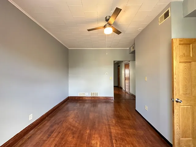 a view of an empty room with wooden floor