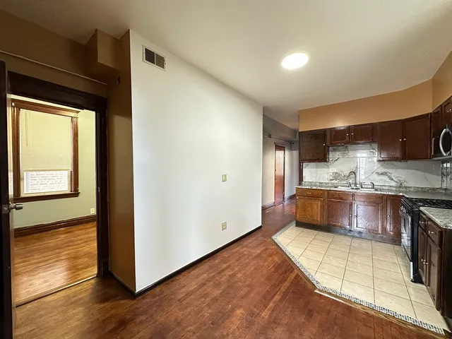 a large kitchen with stainless steel appliances granite countertop a stove and a refrigerator