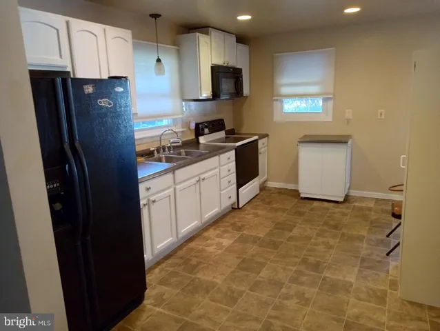 a kitchen with stainless steel appliances granite countertop a refrigerator a stove top oven a sink and dishwasher
