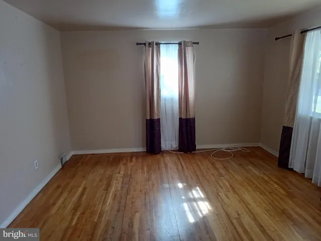 an empty room with wooden floor and entrance