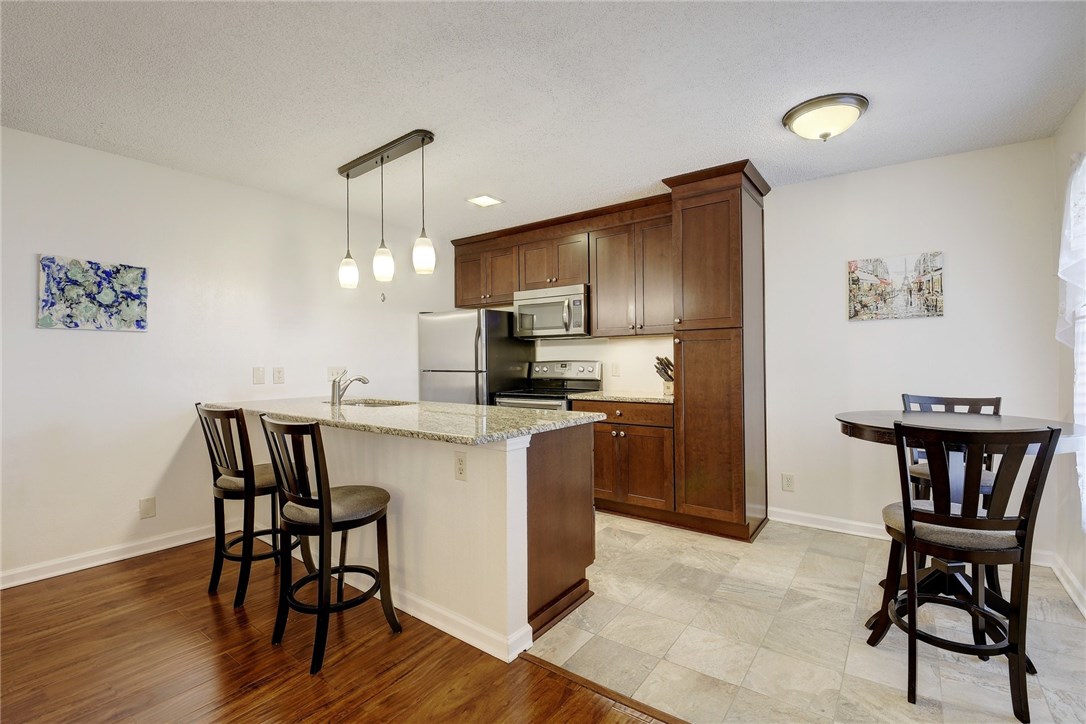 910 Duncan Lane, Unit 60 Austin, TX 78705 - Photo 1 of 1 a kitchen with kitchen island a dining table and chairs