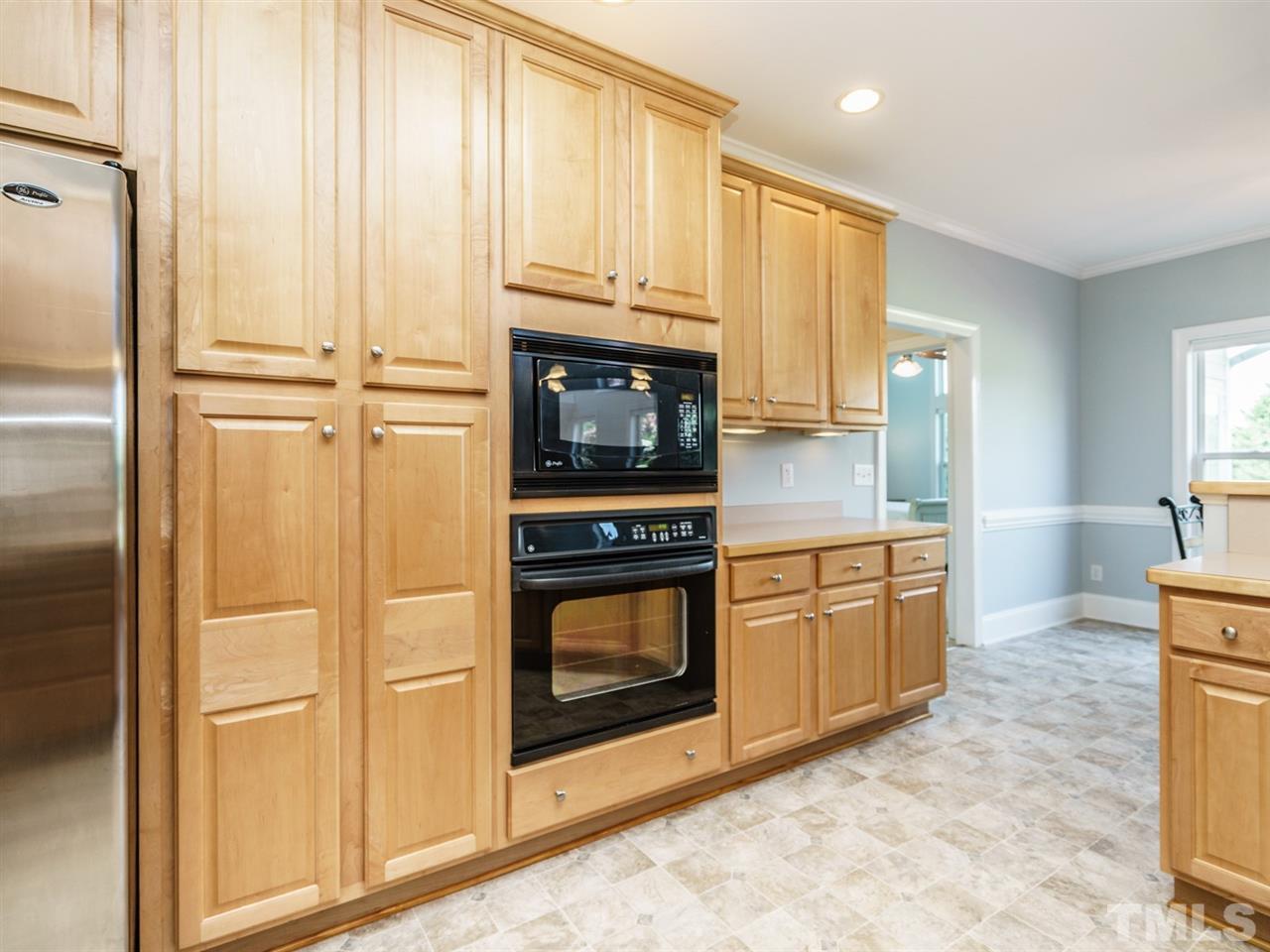 95 Rand Road Raleigh, NC 27603 - Photo 4 of 25 a kitchen with stainless steel appliances granite countertop a stove a sink and a refrigerator with white cabinets