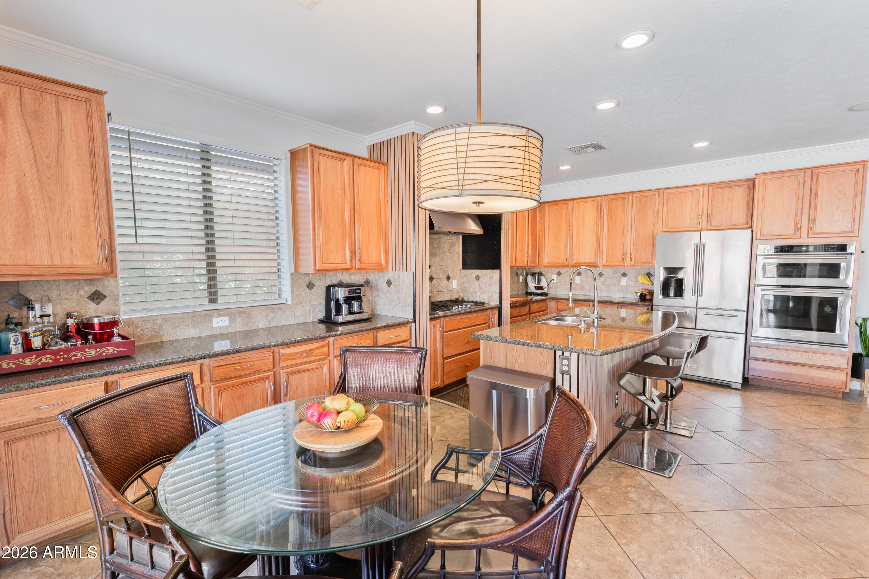 6530 West Bent Tree Drive Phoenix, AZ 85083 - Photo 12 of 42 a kitchen with stainless steel appliances granite countertop a stove a kitchen island a table and chairs in it