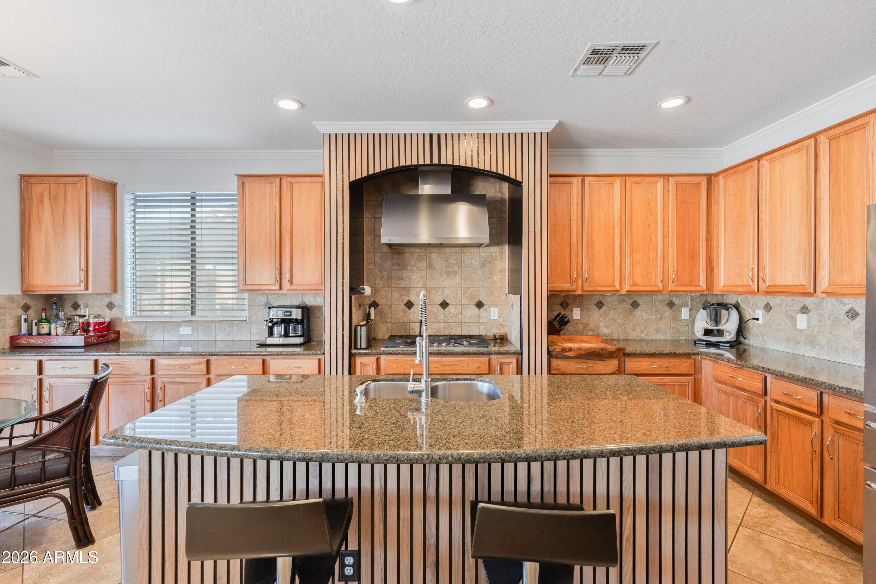 6530 West Bent Tree Drive Phoenix, AZ 85083 - Photo 13 of 42 a kitchen with stainless steel appliances a table chairs in it and wooden floor