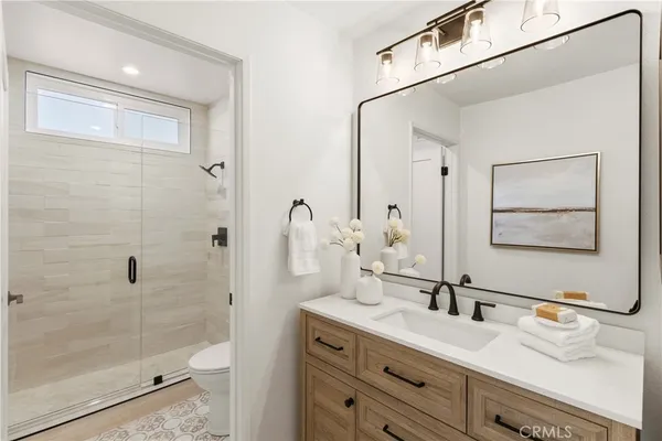 a bathroom with a granite countertop sink a toilet and shower