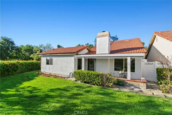 a front view of a house with a garden and plants