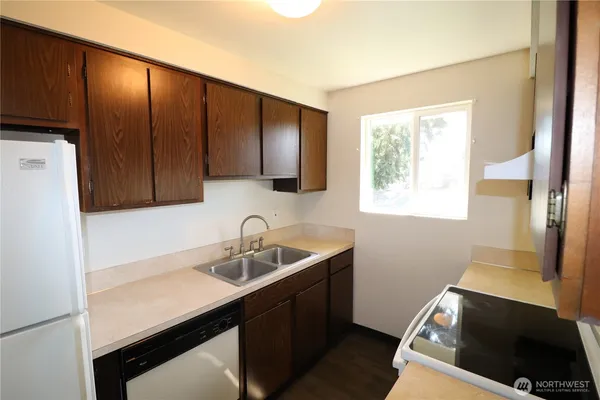 a kitchen with a sink cabinets and window