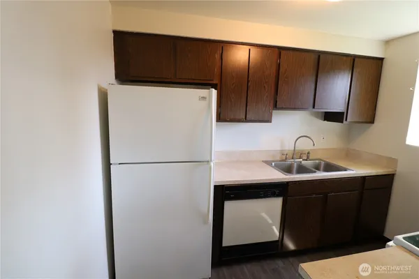 a kitchen with a sink a refrigerator a washer and dryer